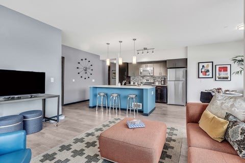 a living room with a couch and a kitchen with a blue island