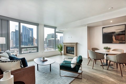 a living room with a large window and a table and chairs