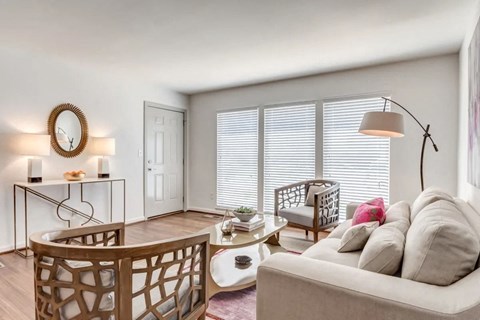 a living room with a couch and a chair and a window