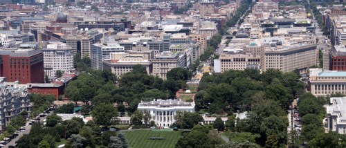 A picturesque view of the White House in Washington, D.C., surrounded by lush greenery and iconic landmarks.
