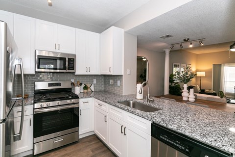 a kitchen with granite counter tops and stainless steel appliances at Willowest in Collier Hills, Atlanta, GA, 30318